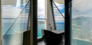 a bathroom with a black tub in front of a window at Boton Blue Hotel & Spa in Nha Trang