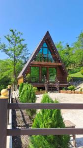 a small wooden house with a fence in front of it at Green Paradise Martvili Cottege in Martvili