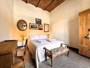 een slaapkamer met een bed, een tafel en een spiegel bij Affaccio su le Lupe in Siena