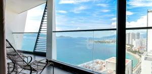a balcony with two chairs and a view of the ocean at Boton Blue Hotel & Spa in Nha Trang