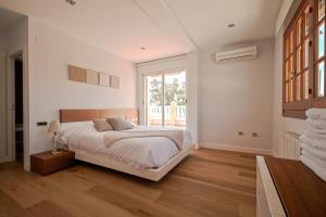 a white bedroom with a bed and a window at Gran casa Velero - Exclusividad, sol y mar in Alicante