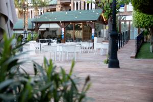 a group of white tables and chairs on a patio at Hotel Boutique Calas de Alicante in Alicante