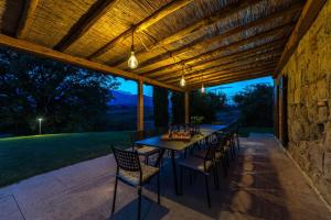 a patio with a table and chairs under a wooden ceiling at Il Poderuccio 17, Emma Villas in Cetona