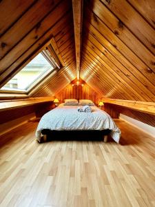 a bedroom with a bed in a wooden attic at Appartement tout confort aux portes de Rennes in Pont-Péan