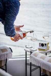 a person pouring a bottle of wine into two glasses at No 42 by GuestHouse, Margate in Margate