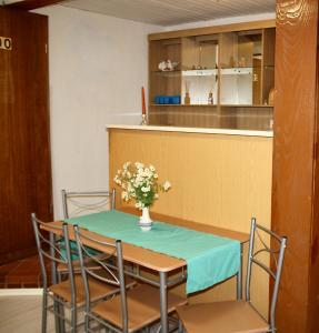 a table and chairs with a vase of flowers on it at Apartment Ferienwohnung Landliebe in Oberwittstadt