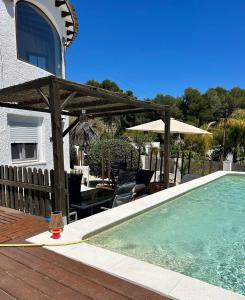 una piscina con ombrellone e sedie accanto a una casa di Studio Apartment in Beautiful Chalet, Finca FAZ a Jávea