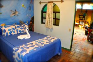 a bedroom with a bed with a blue and white bedspread at Cabo Inn in Cabo San Lucas