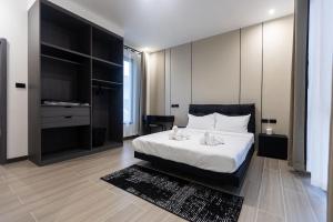 a bedroom with a large white bed and a television at Sun Sky Pool Villa 5 Bed Group Friendly BBQ KTV in Pattaya South