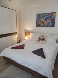 a bedroom with a white bed with towels on it at Apartament GabRox in Mamaia Sat/Năvodari