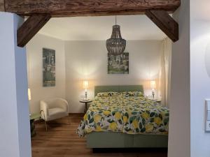 a bedroom with a bed and a chandelier at Schifferkrug Hotel & Weinstube in Celle