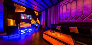 a room with a stage and a tv and purple lighting at Boton Blue Hotel & Spa in Nha Trang