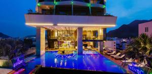 a large building with a swimming pool at night at Boton Blue Hotel & Spa in Nha Trang