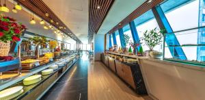 a restaurant with long counters and windows and plants at Boton Blue Hotel & Spa in Nha Trang