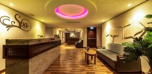 a lobby with a couch and a pink light on the ceiling at Boton Blue Hotel & Spa in Nha Trang