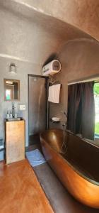 La salle de bains est pourvue d'une grande baignoire en bois et d'un lavabo. dans l'établissement Minh Hầu Lạc Trú Homestay, à Ấp Long Hồ Hạ