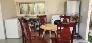 Il comprend une cuisine équipée d'une table, de chaises et d'un lave-vaisselle. dans l'établissement Minh Hầu Lạc Trú Homestay, à Ấp Long Hồ Hạ