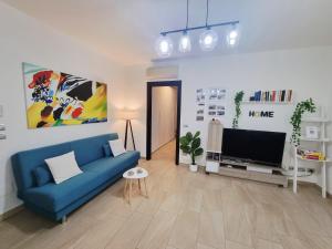 アルゲーロにあるRic’s Houseの青いソファとテレビのあるリビングルーム