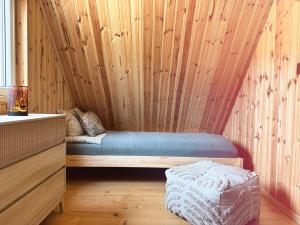 a room with a bed in a wooden wall at Domek Las nad jeziorem in Bożepole Królewskie