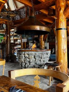 a stone fireplace in a restaurant with a table and chair at Jatak Cabins and Camping in Petnjica