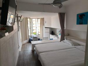 une chambre d'hôtel avec deux lits et une cuisine dans l'établissement Alma de Mar, à La Pineda
