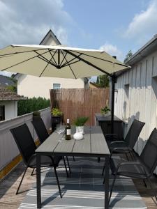 a patio with a table and an umbrella at Ferienwohnung Sonnenblick in Detmold