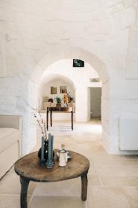 a living room with a table and an archway at Trullo dei Cinque in Cisternino