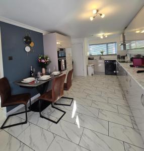 a kitchen and living room with a table and chairs at Luxury Modern Comfy 3BR House Contractors Family in Kettering