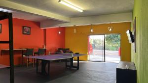 a ping pong table in a room with orange walls at Miners Rest Lodge in Phalaborwa