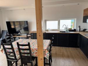 a kitchen with a table and chairs and a kitchen with a counter at Stodoła skamieniałe wzgórze in Tursko