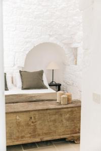 a bedroom with a bed in a white brick wall at Trullo dei Cinque in Cisternino