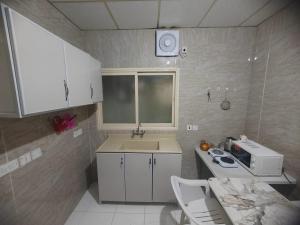 a small kitchen with a sink and a microwave at Al Eairy Apartments - Al Ahsa -2 in Al Ahsa +59 photos