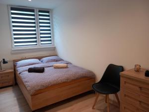 a bedroom with a bed and a chair and a window at Baza Wypadowa 2 in Lubań