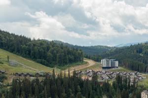 a town on a hill with trees and a building at NEW Premium Club SPA in Bukovel