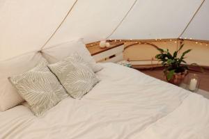 a white bed with three pillows on it at Täheonni Glämping in Tautsa
