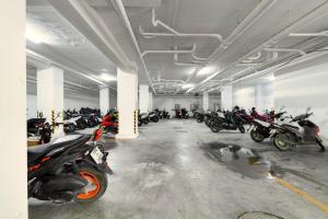 Un estacionamiento con un montón de motocicletas estacionadas en él. en Room 303 Rawai Beach Condo, en Nai Harn Beach