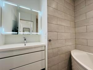 Un baño con lavabo, bañera y espejo. en Îlot lac Central et moderne, en Annecy 13 fotos más