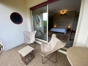 einen Balkon mit einem Bett, einem Tisch und Stühlen in der Unterkunft Villa avec Piscine Intérieure, 5 Chambres, Proche Plage et Commerces à Arcachon - FR-1-374-220 in Arcachon + 22 Fotos