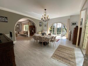 ein Esszimmer mit Tisch und Stühlen in einem Wohnzimmer in der Unterkunft Villa avec Piscine Intérieure, 5 Chambres, Proche Plage et Commerces à Arcachon - FR-1-374-220 in Arcachon