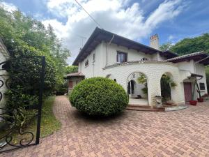 ein großes weißes Haus mit einer Ziegelsteinfahrt in der Unterkunft Villa avec Piscine Intérieure, 5 Chambres, Proche Plage et Commerces à Arcachon - FR-1-374-220 in Arcachon