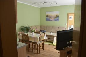 a living room with a table and a couch at Ferienwohnung Morgensonne in Ueckeritz