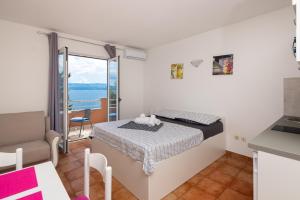 a bedroom with a bed and a view of the ocean at Adriatic Blue Apartments in Lokva Rogoznica