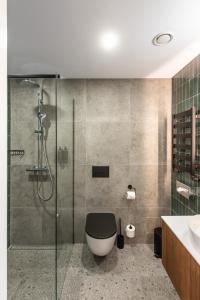 a bathroom with a toilet and a glass shower at AIRINN Vilnius Airport Hotel RENOVATED 2025 in Vilnius