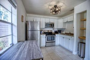 eine Küche mit weißen Schränken und einem Edelstahlkühlschrank in der Unterkunft Downtown Home With Fire Pit, Just 5 Min to Beach in Sarasota + 21 Fotos