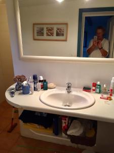 a man taking a picture of a bathroom sink at Bauernhaus mit großem Garten in Jordløse