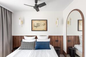 a bedroom with a bed and a ceiling fan at AIRINN Vilnius Airport Hotel RENOVATED 2025 in Vilnius