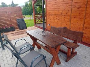 a wooden table and a chair on a patio at Temeszówka domek do wynajęcia in Temeszów