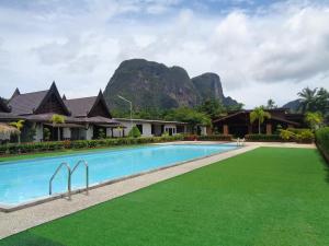 a resort swimming pool with a mountain in the background at PARADIS VERT in Ban Khao Thong
