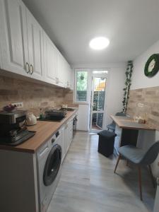 a kitchen with white cabinets and a washing machine at Apartament Zeuss Neptun in Neptun