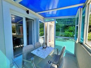 a dining room with a glass table and a pool at Apartments Scheich in Šilo